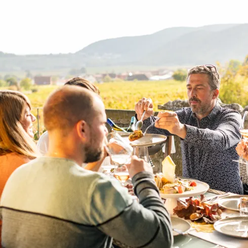 Menschen genießen ein Dinner im Außenbereich des Leinsweiler Hofs. 