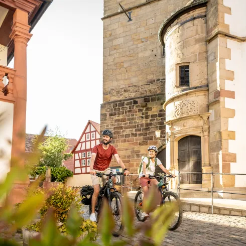 Zwei Personen fahren mit dem Rad durch die Altstadt von Freinsheim.