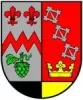 Das Ortswappen von Würzweiler zeigt Lilien und Hopfen auf der linken und Spangen und eine Krone auf der rechten Hälfte